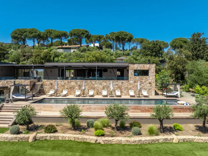Façade en pierre et piscine d'un hébergement de Pinarello